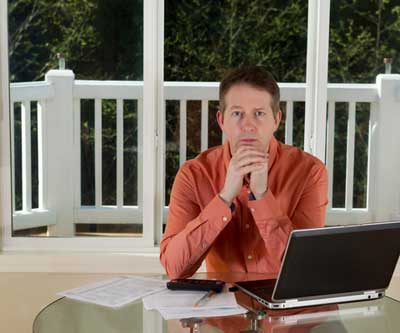 Man Managing Rental Properties from Home on the Computer 